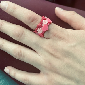 Apple blossom stackable silicone ring with pink heart light pink flower and cranberry leaf pictured on hand